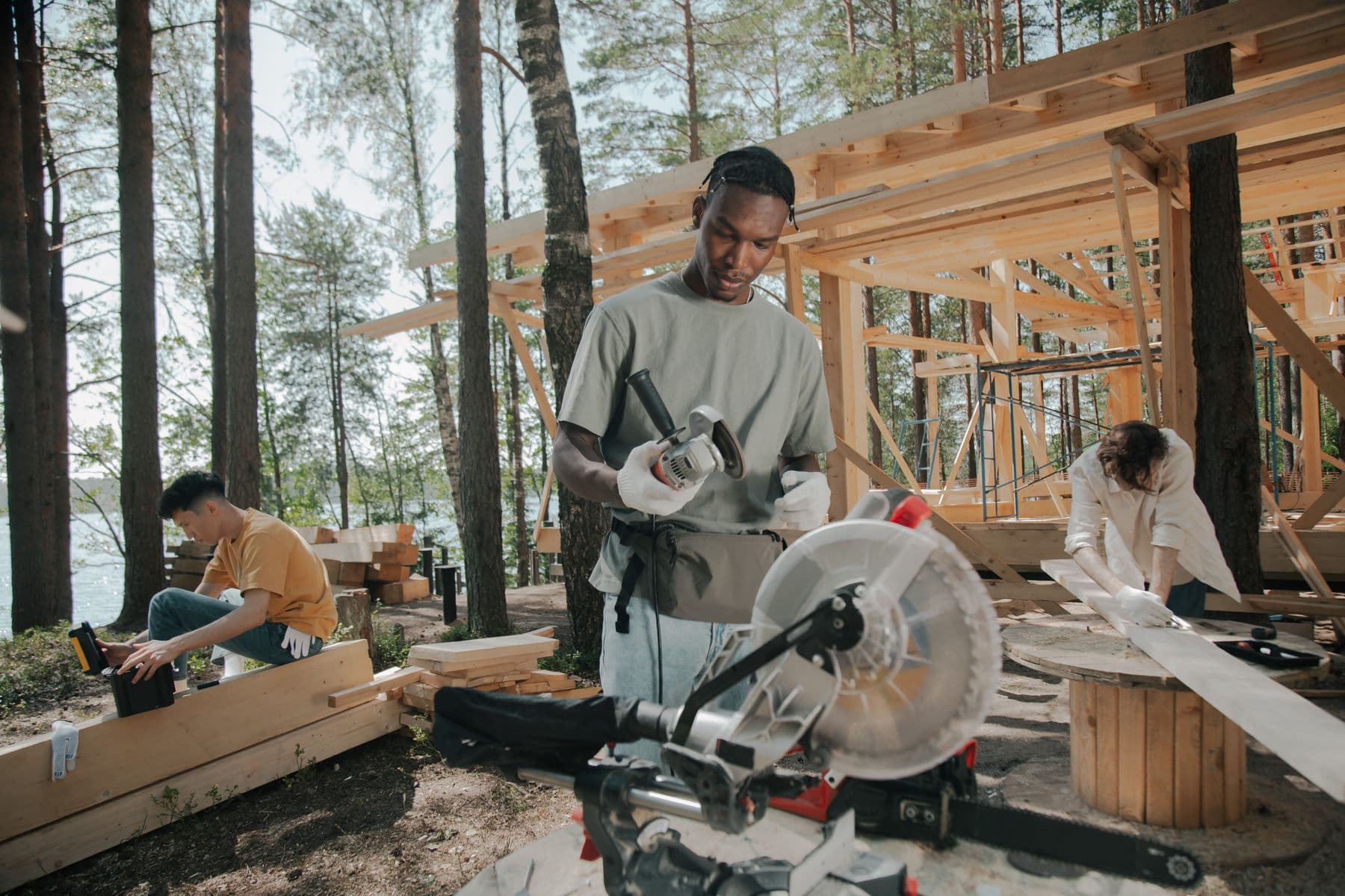 A construction crew building a timber-framed home together on a bright day