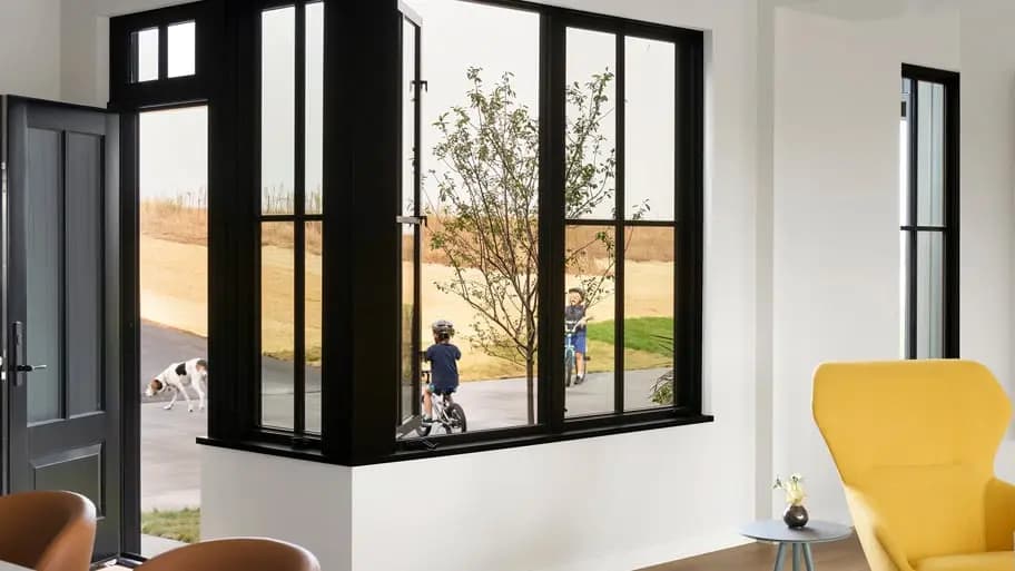 Black-framed Andersen E-Series windows in a bright modern room