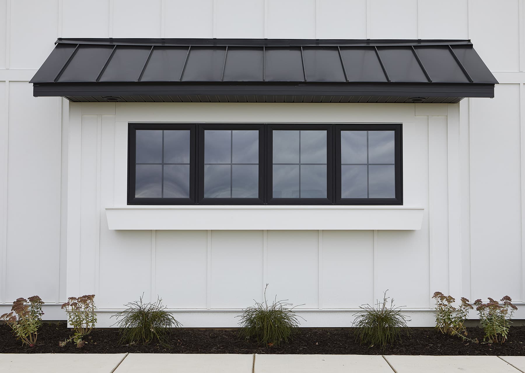 A coastal or modern-farmhouse home clad in AZEK cellular-PVC board-and-batten siding