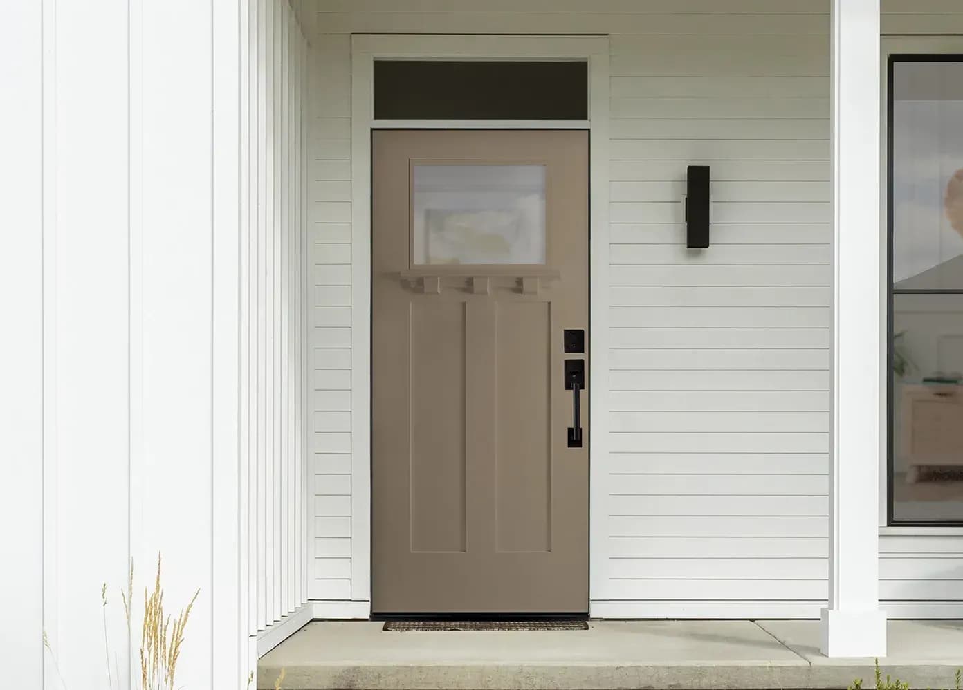 A craftsman-style Masonite entry door framed by sidelights in a finished entryway