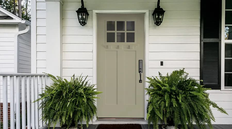 A green craftsman-style Pella entry door on a home's front entry