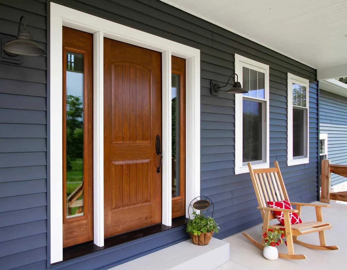 A warm-stained fiberglass ProVia entry door set in a covered front entry