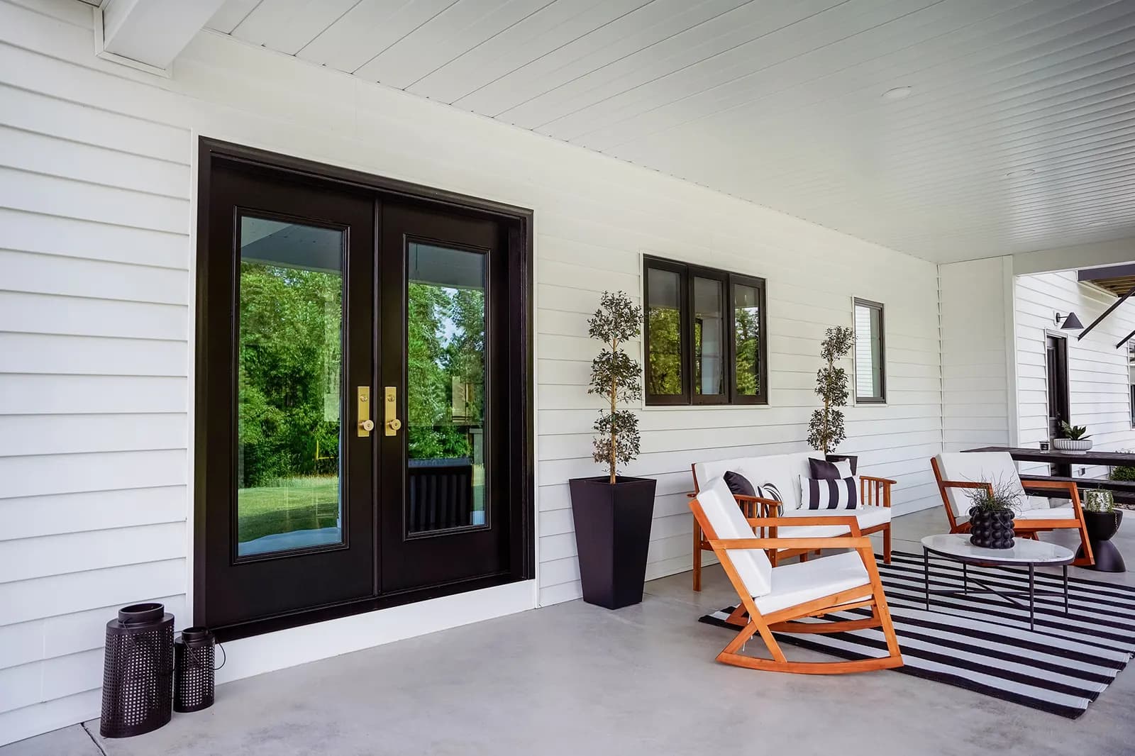 A black steel ProVia entry door framed by sidelights in a finished entryway