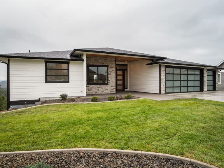 A white single-story modern prairie home with black-framed windows clad in LP SmartSide lap siding