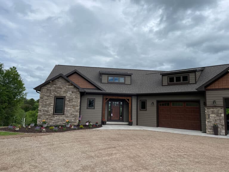 A greige craftsman home with stone and a cedar-wrapped entry, clad in LP SmartSide lap siding