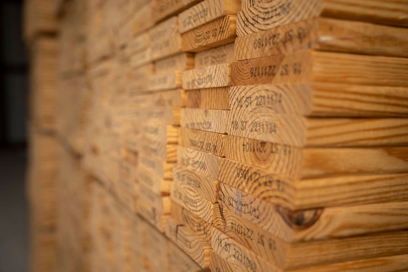 Close-up of neatly stacked kiln-dried framing lumber with visible grade stamps
