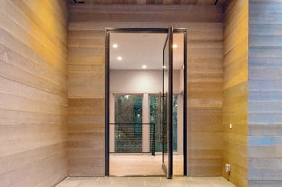 Andersen pivot glass door opening a room onto a deck and yard