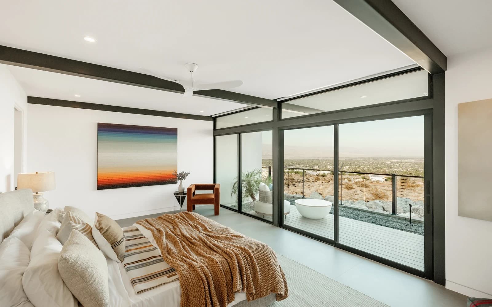Western multi-slide glass wall opening a room onto a deck and yard