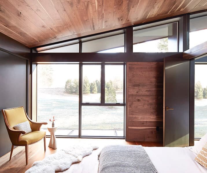Pella Reserve contemporary black-framed angled windows in a modern room