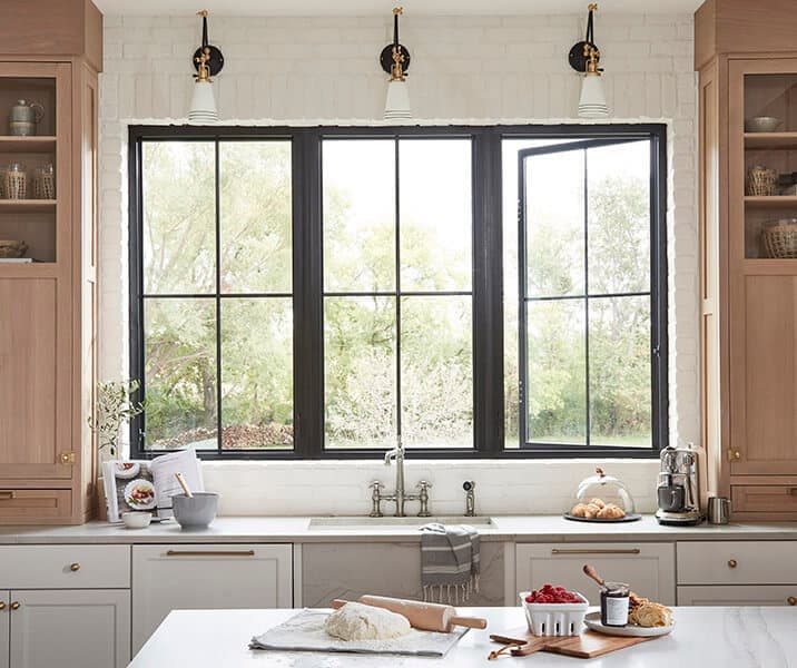 Black-framed Pella Impervia casement windows over a kitchen sink